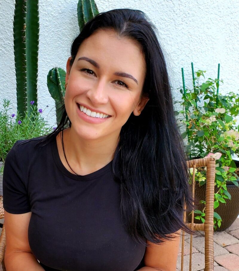 Diana Rosique smiling, seated outdoors among potted plants